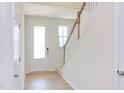 Bright entryway with hardwood floors, white door, and staircase at 86 Barn Door Dr, Lillington, NC 27546