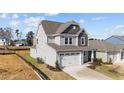 Two-story house with gray siding, white garage door, and landscaping at 86 Brooklynn Trl, Angier, NC 27501