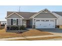 Gray siding house with white garage door and landscaping at 8798 Kenridge Ln, Fuquay Varina, NC 27526