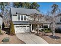 Lovely two-story home featuring a two-car garage, mature trees, and a well-maintained lawn at 104 Warm Wood Ln, Apex, NC 27539