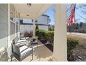 Relaxing front porch featuring wicker seating, tasteful plantings, and traditional columns at 104 Warm Wood Ln, Apex, NC 27539