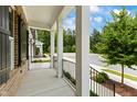 Covered porch with black railing, brick and white columns at 1135 Laurelwood Dr, Durham, NC 27705