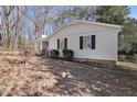 Side view of a white single story house with black shutters and landscaping at 1437 Huntly Ct, Cary, NC 27511