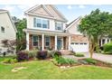 Attractive two-story home boasts lush landscaping, a stone facade, and a cozy front porch area at 200 Callandale Ln, Durham, NC 27703