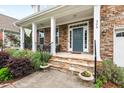 Inviting front porch with stone columns, steps, stylish railings, and decorative potted plants at 200 Callandale Ln, Durham, NC 27703