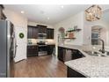 Spacious kitchen with dark cabinets, granite countertops, and stainless steel appliances at 206 Maple Walk St, Durham, NC 27703