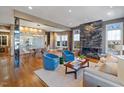 Open floor plan living area with hardwood floors, a stunning granite fireplace and large windows at 255 Penley Cir, Raleigh, NC 27609