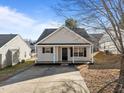 A quaint single-story home featuring a compact layout, a covered front porch, and an extended concrete driveway at 2613 Lilymount Dr, Raleigh, NC 27610