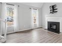 Living room with fireplace, hardwood floors, and large windows at 706 Sleepy Creek Dr, Durham, NC 27713