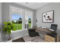 Bright home office features large windows, a glass-top desk, and hardwood floors at 93 Macy Cir, Wendell, NC 27591