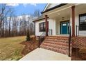 Brick steps leading to a teal front door with modern railing at 195 Daniel Ridge Ln, Roxboro, NC 27574