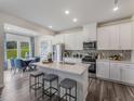 Modern kitchen featuring white cabinetry, stainless steel appliances, and a large island with seating at 2009 Cherry Creek Rd, Haw River, NC 27258