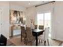Bright dining room featuring a modern table, stylish chairs, contemporary art, and a large window at 2015 Cherry Creek Rd, Haw River, NC 27258