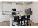 Modern kitchen with stainless steel appliances, granite countertops, white cabinets, and bar stool seating at 2015 Cherry Creek Rd, Haw River, NC 27258