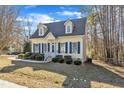 Cute yellow house with blue shutters and landscaping at 215 W Chestnut Ave, Wake Forest, NC 27587