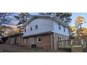 Rear view of a two-story brick home with a combination of siding and a wooden deck at 2300 Radius Cir, Sanford, NC 27330