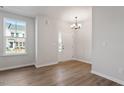 Bright living room with hardwood floors, a modern chandelier, and natural light from a large window at 277 Chesapeake Commons St # 94, Garner, NC 27529
