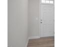 Minimalist entryway features white door with sidelights and wood-look flooring at 34 Fairwinds Dr, Lillington, NC 27546