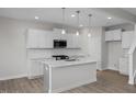 Bright kitchen with white cabinets, quartz countertops, stainless appliances, and large island at 34 Fairwinds Dr, Lillington, NC 27546