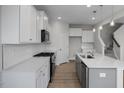 Well-appointed kitchen features white cabinets, quartz countertops, and stainless steel appliances at 34 Fairwinds Dr, Lillington, NC 27546