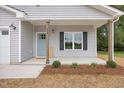 Inviting front porch with light blue door and landscaping at 435 Iris Bryant Rd, Dunn, NC 28334
