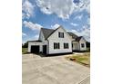 Beautiful white two-story home with black shutters and a large driveway leading to the garage at 5377 River Buck Rd, Spring Hope, NC 27882