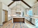 Bright kitchen featuring white cabinets, a center island, stainless steel appliances, and vaulted ceilings at 5820 Shawood Dr, Raleigh, NC 27609