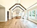 Open-concept gourmet kitchen featuring a vaulted ceiling, light cabinets, and wood beams at 5820 Shawood Dr, Raleigh, NC 27609