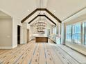 Open-concept room with vaulted ceiling, wood beams, modern light fixture, and views of the kitchen at 5820 Shawood Dr, Raleigh, NC 27609