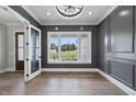 A formal living room with decorative molding, chandelier, hardwood floors, and natural light at 5820 Shawood Dr, Raleigh, NC 27609
