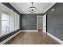 A formal living room with decorative molding, hardwood floors, chandelier, and open doorway at 5820 Shawood Dr, Raleigh, NC 27609