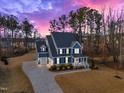 Aerial view of a stunning two-story home with an extended driveway, surrounded by lush greenery at 72 Florentino Ct, Clayton, NC 27527