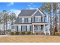 Traditional two-story home with a covered front porch, manicured lawn, and classic curb appeal on a bright, sunny day at 72 Florentino Ct, Clayton, NC 27527