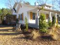 Side view of a charming white house with a wrap-around porch at 815 N Durham Ave, Creedmoor, NC 27522