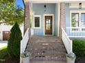 Inviting front porch with brick steps and columns, offering a cozy entrance to the home at 1000 Norris St, Raleigh, NC 27604