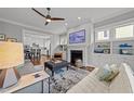 Cozy living room with fireplace, built-in shelves, ceiling fan and a seamless transition to the kitchen at 1000 Norris St, Raleigh, NC 27604