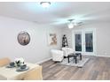 Bright living room with hardwood floors, white accent chairs, and French doors at 103 Cimmaron Ct, Cary, NC 27511