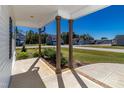 Covered front porch with brown support columns and view of neighborhood at 16 Sourgum Ct Ct, Zebulon, NC 27597