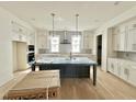 Bright, spacious kitchen with white cabinetry, a large island, and stainless steel appliances at 1725 Burnette Garden Path, Raleigh, NC 27612