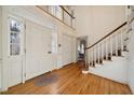 Two-story entryway with hardwood floors, a staircase, and coat closet at 2700 Sherborne Pl, Raleigh, NC 27612