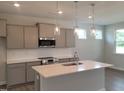 Modern kitchen with stainless steel appliances, a quartz island, and pendant lighting at 53 Priming Way, Angier, NC 27501