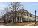 Two-story house with light beige siding, brown shutters, and a covered porch at 9306 Alcazar Walk, Raleigh, NC 27617