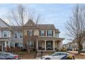 Two-story house with light beige siding, brown shutters, and a covered porch at 9306 Alcazar Walk, Raleigh, NC 27617
