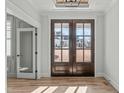 Bright entryway with hardwood floors and double French doors at 100 Sire Ct, Holly Springs, NC 27540