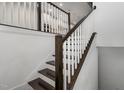 Modern staircase with dark wood railings and white balusters at 10310 Sablewood Dr # 108, Raleigh, NC 27617