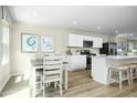 Kitchen and dining area with light wood floors and white furniture at 104 Cavalier Rider Run, Wendell, NC 27591