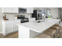 White kitchen island with quartz countertops and stainless steel sink at 104 Cavalier Rider Run, Wendell, NC 27591