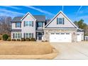 Two-story house with gray siding, stone accents, and a three-car garage at 139 Red Angus Dr, Smithfield, NC 27577
