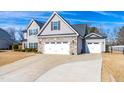 Two-story house with gray siding, stone accents, and a three-car garage at 139 Red Angus Dr, Smithfield, NC 27577