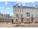 Tan three-story townhome with dark gray roof and landscaping at 1514 Excelsior Grand Ave, Durham, NC 27713